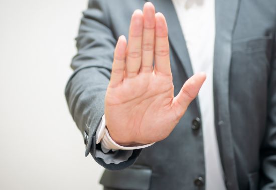 手のひらを前に出して、注意を促す男性の様子