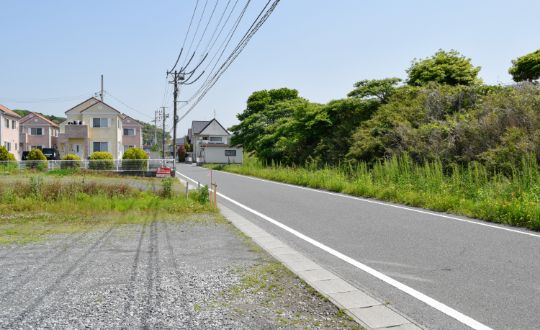 住宅街にある未開発の土地と道路の風景